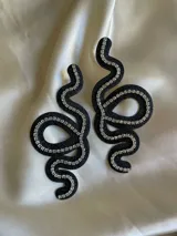 Aros colgantes con forma de serpiente azul contorneada con strass plateado.