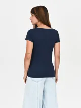 Remera de manga corta color crema, con cuello redondo.