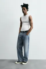 Pantalón de jean gris oscuro, corte amplio, con cinco bolsillos, efecto lavado y cierre frontal con cremallera y botón.