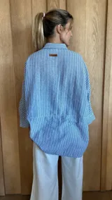 Camisa celeste de corte amplio, con cuello clásico y mangas largas.