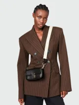 Bolso bandolera mini Marc Jacobs de cuero negro con cierre dorado y correa de tela con logo de la marca.