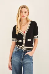 Cardigan negro de viscosa con lurex, manga corta y cierre con botones a presión.