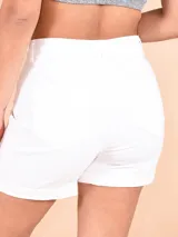 Short de jean blanco con bolsillos delanteros y traseros, y ruedo doblado.