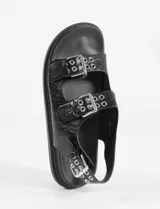 Sandalias plateadas con tiras anchas y plantilla cómoda, con tira ajustable en el talón. Fabricadas en cuero vegano.