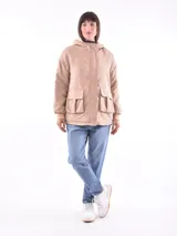 Campera color beige con interior de piel sintética blanca, capucha, cierre frontal con botones a presión, bolsillos laterales con solapa y puños elásticos.