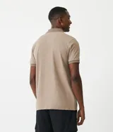 Polo de manga corta color beige, confeccionada en algodón con cuello jacquard y ribete en las mangas.