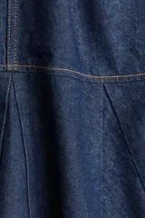 Vestido corto sin mangas en denim azul, con escote redondo y cierre oculto en la espalda. Costura visible en la cadera y pollera acampanada con nesgas para dar vuelo.