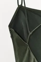 Vestido largo de tirantes finos cruzados en la espalda, confeccionado en tejido satinado color verde oscuro.
