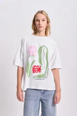 Remera blanca de corte amplio con estampado abstracto de flores en tonos rosa, rojo y verde.