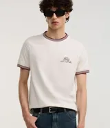 Remera blanca de algodón, corte baby tee, con cuello redondo y mangas cortas con ribete doble en bordó. Estampa pequeña con texto "The Staff" en el pecho.