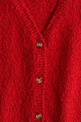 Cárdigan rojo de tejido slub con cuello en V, manga corta y cierre frontal con botones.