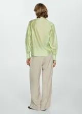 Camisa color verde claro de tejido satinado, manga larga con puños abotonados, diseño recto, cuello camisero y cierre delantero con botones.