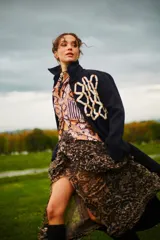 Tapado de paño de lana negro, de corte clásico, con intervención lateral de cinta de algodón bordada a mano. Cuenta con dos bolsillos delanteros.