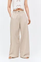 Pantalón de corte holgado color beige, confeccionado en mezcla de lino. Modelo de tiro alto con cierre y botón, bolsillos al bies, bolsillos insertados atrás y piernas amplias.