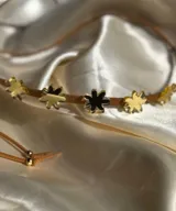 Gargantilla de cuero marrón con doble tira y dijes de flores espejadas.