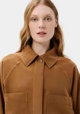 Camisa color marrón con cuello clásico, cierre frontal con botones, mangas largas y dos bolsillos de parche en el pecho.