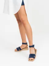 Vestido camisero corto, color azul, con cuello solapa, manga larga y bolsillo delantero de plastrón. Presenta un bajo asimétrico.