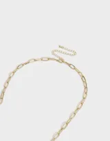 Collar dorado con cadena de eslabones y dije de corazón, dije de corazón calado, dije de cristal y dije de piedra verde.
