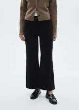 Pantalón culotte de pana negra, tiro alto, con cierre de cremallera y botón, trabillas, dos bolsillos de parche delanteros y dos traseros. Diseño crop.