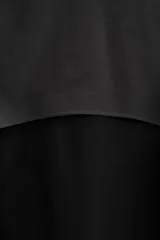 Cazadora con capucha confeccionada en tejido técnico ligero y elástico en todas las direcciones, color negro con detalles en gris. Cuenta con cuello con capucha ajustable, manga larga, bolsillos con cierre de cremallera en cadera, acabados con elástico y cierre frontal de cremallera.