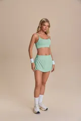 Pollera deportiva color verde lima, con short interno y bolsillo en la cintura.