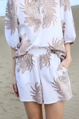 Short blanco con estampado de tigres en tonos marrones, cintura elastizada y bolsillos laterales.