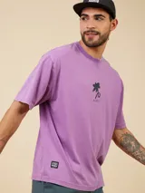 Remera verde esmeralda de algodón con corte relaxed, cuello redondo y estampado de flor en el pecho.