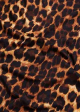 Camiseta de tejido fluido con estampado animal print de leopardo, cuello asimétrico y manga larga.