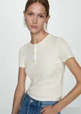 Remera color crema de lyocell con cuello redondo, manga corta, cierre de botones en el cuello y diseño entallado.