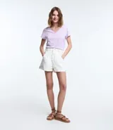 Blusa blanca de algodón con cuello en V, manga corta y bolsillo frontal.