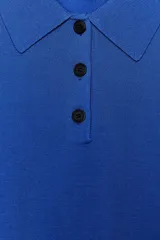 Top azul eléctrico de punto, con cuello polo, manga corta y cierre frontal con botones negros.