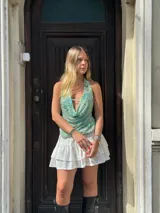 Top verde agua con escote drapeado, espalda descubierta y bordado de flores azules y lentejuelas.