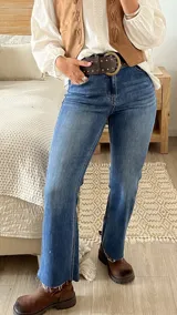 Jean azul de corte recto con terminación deshilachada en el ruedo.