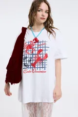 Remera color beige con estampado de sardinas, limones y aceitunas.