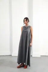 Vestido largo gris sin mangas, con escote redondo, bolsillos laterales y logo bordado en el frente.