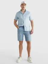 Camisa celeste de mangas cortas, confeccionada en popelín de puro algodón. Tiene cuello abotonado, bajo redondeado y logo de Tommy Hilfiger bordado en el pecho.