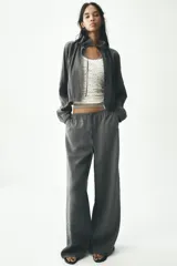 Pantalón palazzo color gris topo de tejido fluido, con cintura elástica ajustable con cordones y bolsillos laterales.