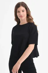 Camiseta negra de algodón orgánico con mangas cortas y volados en el ruedo.