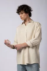 Camisa color arena de lino, manga larga, con cuello clásico y corte holgado.