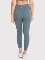 Calza deportiva larga color verde azulado, de tiro alto y calce regular. Confeccionada en tejido suave con tecnología Seamless.