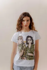Remera blanca de algodón con ilustración de dos mujeres con estilo urbano y detalles metalizados en dorado.