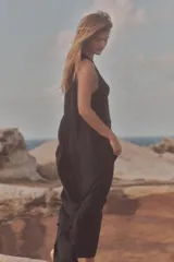 Vestido midi negro de tejido fluido, con cuello redondo y sisa. Cierre trasero con cremallera oculta.