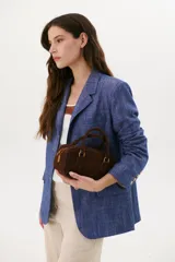 Blazer azul de lino con solapas de muesca, cierre frontal con botón y bolsillos con solapa.