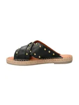 Sandalias negras de cuero con tiras cruzadas y hebilla dorada.
