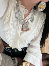 Collar plateado con cadena de eslabones y dijes colgantes de diferentes formas y tamaños, algunos con detalles dorados.