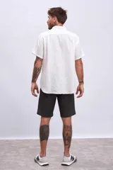 Camisa celeste de lino, de corte clásico, manga corta y cuello italiano.