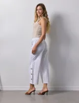Pantalón blanco de algodón con pretina elastizada, bolsillos inclinados y ruedo con botones.