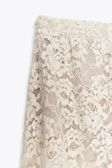 Pantalón bombacho de encaje color crudo, tiro alto, cintura elástica y forro interior.