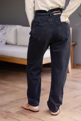 Pantalón de jean celeste de corte babucha con lazo ajustable en la cintura.