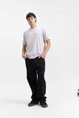 Remera lila de manga corta con cuello redondo y estampado pequeño en el pecho.